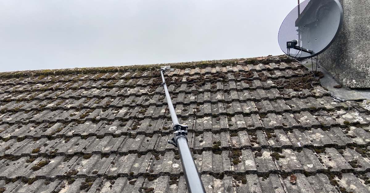 Removing moss from a tiled roof in Southampton as part of a professional roof cleaning service