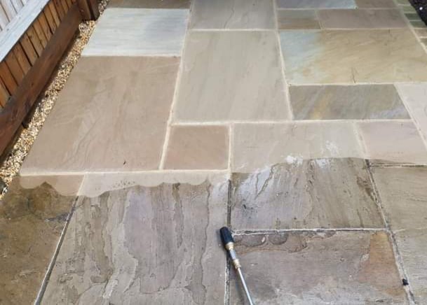 Pressure washing a dirty patio in Southampton to restore its original colour